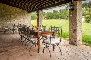 a wooden table and chairs on a patio at Chianti Escape PoolVines Tenuta Bibbiano-I Sodi in Castellina in Chianti