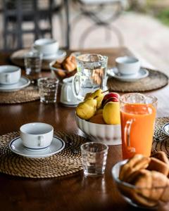 a wooden table with a bowl of fruit and drinks at Chianti Escape PoolVines Tenuta Bibbiano-I Sodi in Castellina in Chianti