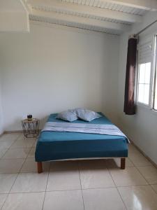 a bedroom with a bed in a white room at Jolie maison avec terrasse in Partarieux