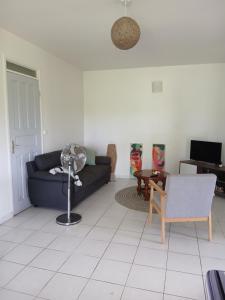 a living room with a couch and a table at Jolie maison avec terrasse in Partarieux