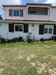 a white house with a yard in front of it at Jolie maison avec terrasse in Partarieux