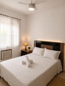 a bedroom with a large white bed with a window at TOP 1 QUARTO com ESTACIONAMENTO em Condomínio com VISTA INCRIVEL - PORTARIA 24h, PISCINA, Sauna e Parquinho Infantil - Apartamento com Ar condicionado, Smart TV, Wi-Fi, Cozinha Completa, NETFLIX, Entre o MAR e a LAGOA, CUSTO BENEFICIO in São Pedro da Aldeia