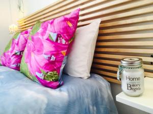 Una almohada con una flor junto a un frasco en Axarquia Apartments, en Nerja