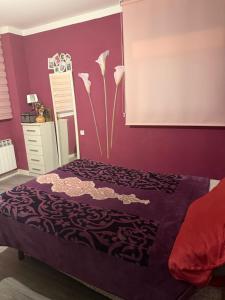 a bedroom with a bed with a purple wall at Apartamento Deluxe city in Burgos