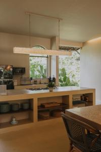 a kitchen with a counter with a sink and a window at Schönhouse Villa Siargao in General Luna
