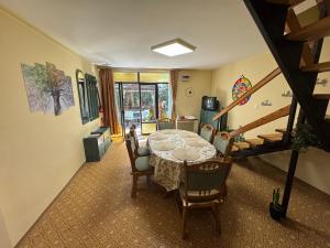 a dining room with a table and chairs and a staircase at Manna Igal Apartman in Igal
