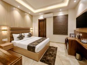 a hotel room with a bed and a television at Palm Bliss A Luxury Hotel in Haridwār