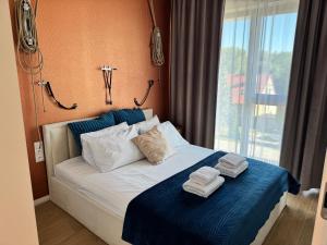 a bedroom with a bed with towels on it at Aqua Concept Apartment Sol Marina in Wiślinka +8 photos