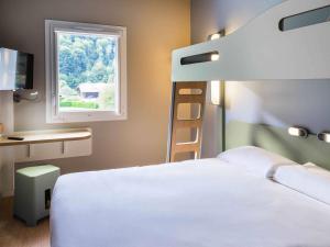 a bedroom with a white bed and a window at Ibis Budget Sallanches in Sallanches