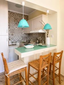 a kitchen with a green counter and two chairs at Farniente Tolo in Tolo