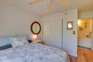 a bedroom with a king sized bed and a mirror at Beachside Molokai Condo w/ Lanai & Pool Access! in Kaunakakai