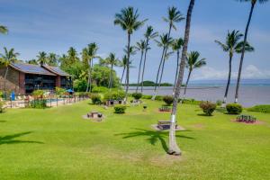 a park with palm trees and a building at Beachside Molokai Condo w/ Lanai & Pool Access! in Kaunakakai