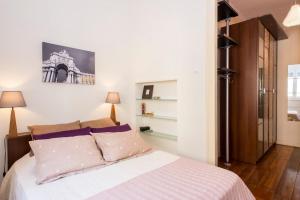 sypialnia z łóżkiem z białą pościelą i poduszkami w obiekcie Find Me Inn Alcantara w Lizbonie