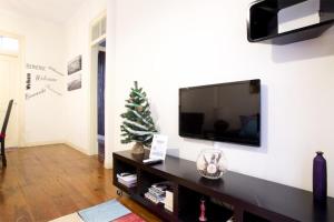 a living room with a television and a christmas tree at Find Me Inn Alcantara in Lisbon