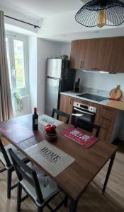 a kitchen with a wooden table with chairs and a kitchen at L'olivier de Jeanine in Contes