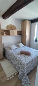 a bedroom with a bed with a blue and white blanket at L'olivier de Jeanine in Contes +12 photos