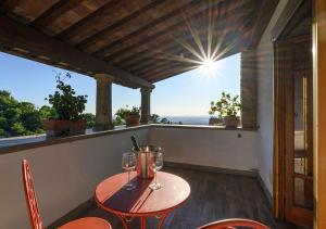 a table with two wine glasses on a balcony at B&B Locanda Cistercense in San Martino al Cimino