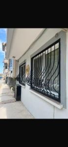 a white building with black barred windows on it at Defne House Urla in Urla