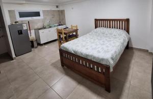 a bedroom with a bed and a kitchen with a refrigerator at BO Alquileres Temporarios in Ushuaia +7 photos