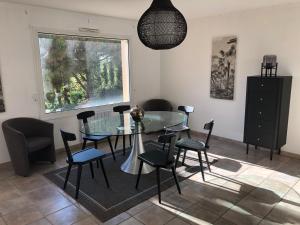 a dining room with a glass table and chairs at Villa Arethuse - Pyla sur Mer in Pyla-sur-Mer