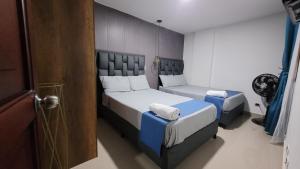 a small bedroom with two beds and a door at Estudio cerca a puerta del norte in Bello