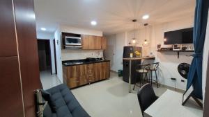 a small kitchen with wooden cabinets and a blue couch at Estudio cerca a puerta del norte in Bello