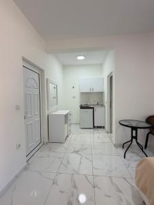 a white room with a table and a kitchen at Duraku Apartments in Ulcinj