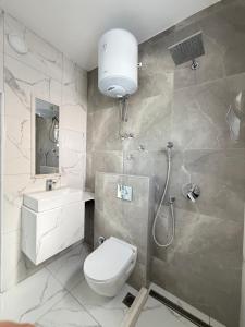 a bathroom with a toilet and a sink and a shower at Duraku Apartments in Ulcinj
