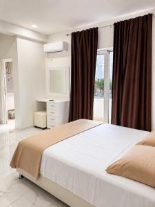 a bedroom with a large bed and a television at Duraku Apartments in Ulcinj