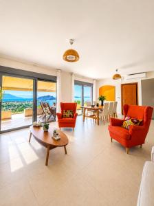 a living room with orange chairs and a table at Villa Harmonia in Egina
