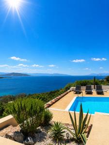 a villa with a swimming pool and a view of the ocean at Villa Harmonia in Egina