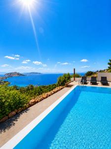 a villa with a swimming pool with a view of the ocean at Villa Harmonia in Egina
