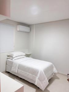 a white bedroom with a white bed and a window at Laguna Sun Set in Salinópolis +21 photos