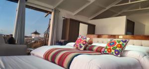 a bedroom with two beds with colorful pillows at Titicaca wasy lodge in Puno