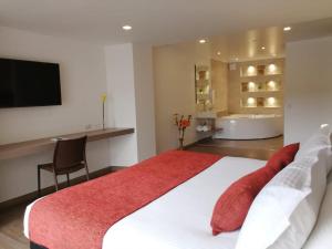 a bedroom with a large bed and a bathroom at Daza Hotel in Paipa