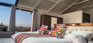 a bedroom with two beds and a large window at Titicaca wasy lodge in Puno +19 photos