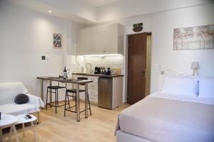 a bedroom with a bed and a kitchen with a table at Nook Athens Airport in Spata