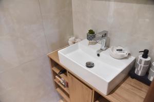 a bathroom with a white sink and a shower at Nook Athens Airport in Spata +18 photos