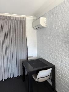 a black desk with a chair and a white wall at Bribie Waterways Motel in Bongaree