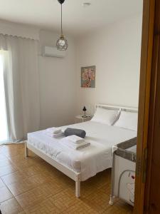 a bedroom with a white bed and a lamp at Evelyn House in Samos