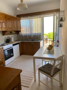 a kitchen with a white table and a table and a window at Evelyn House in Samos