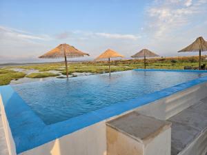 a swimming pool with umbrellas on top of it at COMPORTA SIDE - Tents in Setúbal +46 photos
