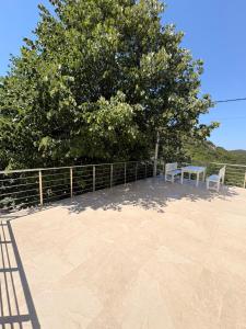 a patio with two chairs and a tree at Sea&Forest view in Buljarica