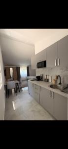 a kitchen with white cabinets and a dining room at Sea&Forest view in Buljarica