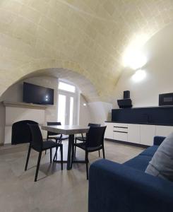 a living room with a table and chairs and a couch at Radici 1892 in Montescaglioso +2 photos