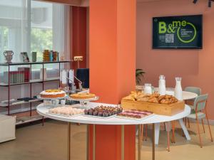 a table filled with different types of pastries and pies at B&B HOTEL Padova Methis in Padova