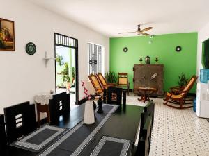 a living room with green walls and a table and chairs at Casa Hotel La Unión in Santa Cruz de Mompox