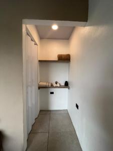 a hallway with a white wall and a white door at Altima Arenal Volcano View in Tanque