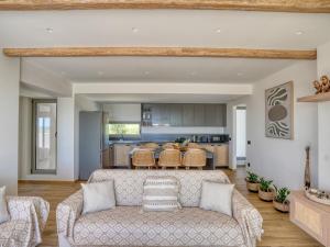 an open living room with a couch and a kitchen at Villa Dioni in Kardamaina
