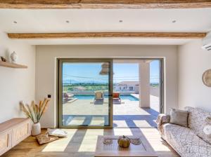 a living room with a glass door leading to a pool at Villa Dioni in Kardamaina